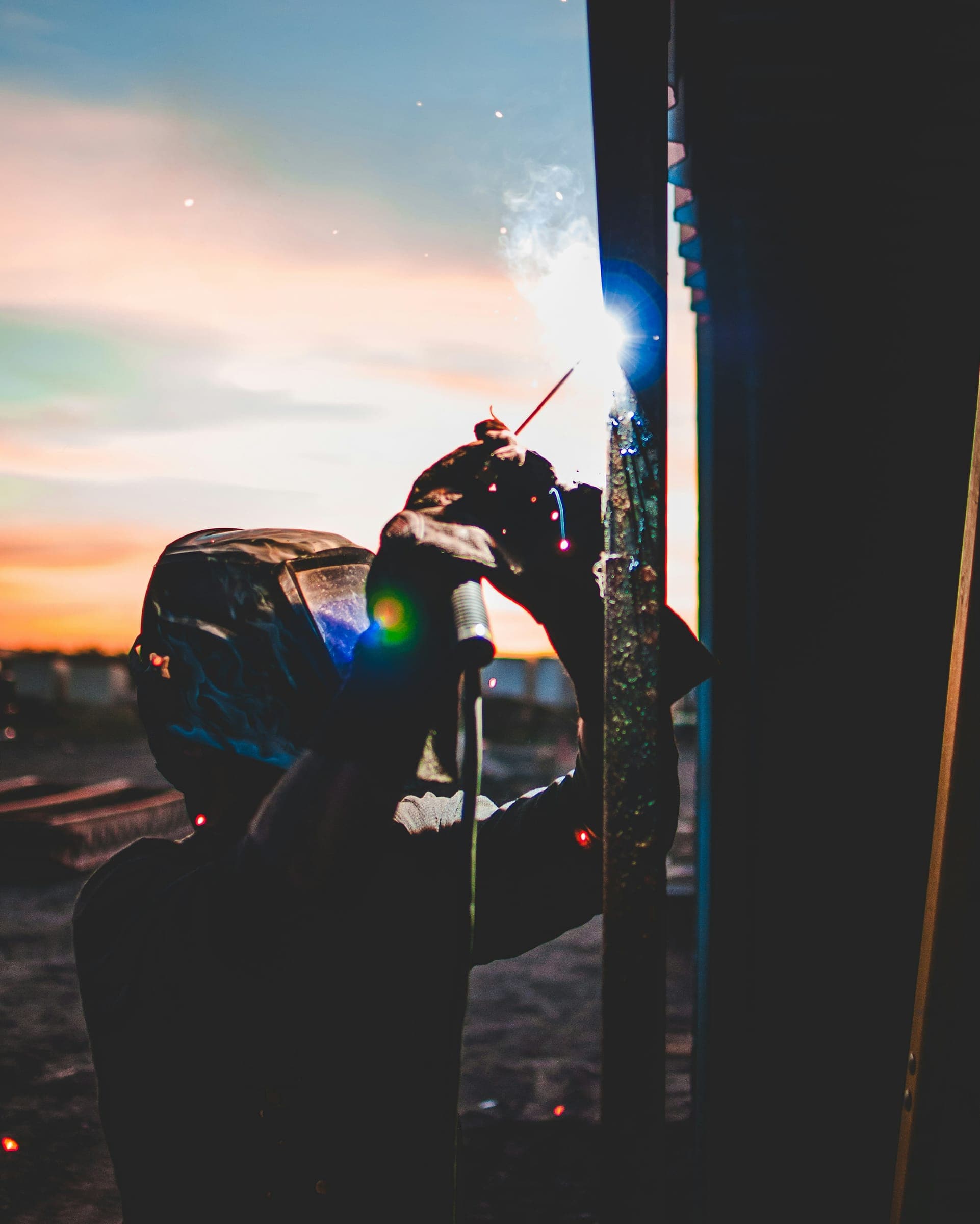 A welder working on structural steel at the end of the day